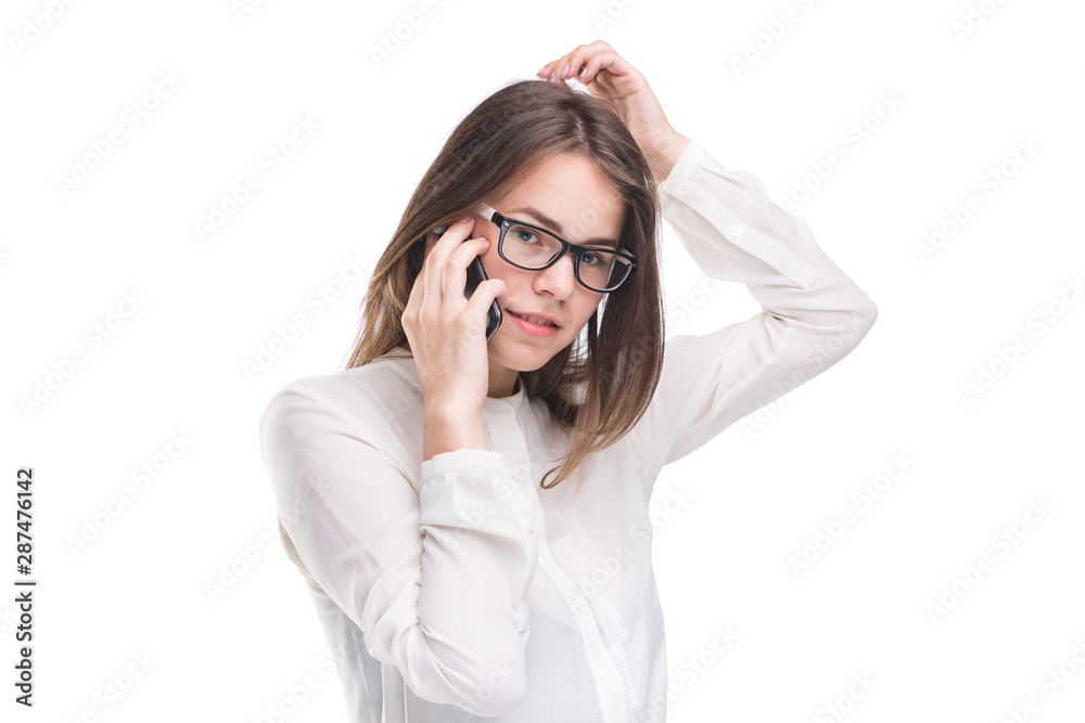 Smiling businesswoman in glasses talking on mobile phone. Beautiful young girl in white shirt on white isolated background talking on mobile phone. Woman in shirt with cellphone. Copy space. Blank Smiling businesswoman in glasses talking on mobile phone. Beautiful young girl in white shirt on white isolated background talking on mobile phone. Woman in shirt with cellphone. Copy space. Blank