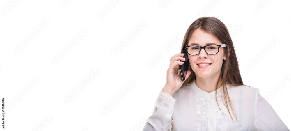 Smiling businesswoman in glasses talking on mobile phone. Beautiful young girl in white shirt on white isolated background talking on mobile phone. Woman in shirt with cellphone. Copy space. Blank Smiling businesswoman in glasses talking on mobile phone. Beautiful young girl in white shirt on white isolated background talking on mobile phone. Woman in shirt with cellphone. Copy space. Blank