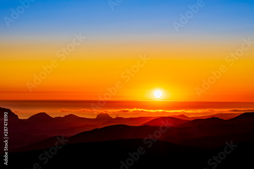 Orange Sunset, Hills, Ocean, silhouetted