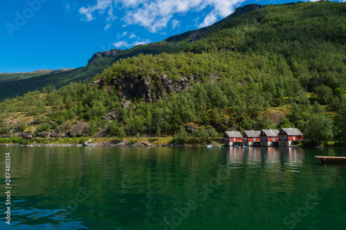 A row of red small house with small boats at Flam, Norway. July 2019