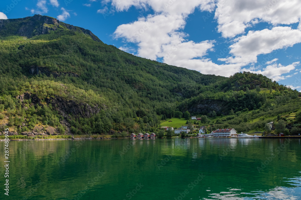 A row of red small house with small boats at Flam, Norway. July 2019