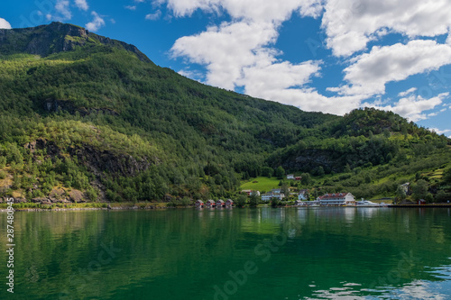 A row of red small house with small boats at Flam, Norway. July 2019 © Сергій Вовк
