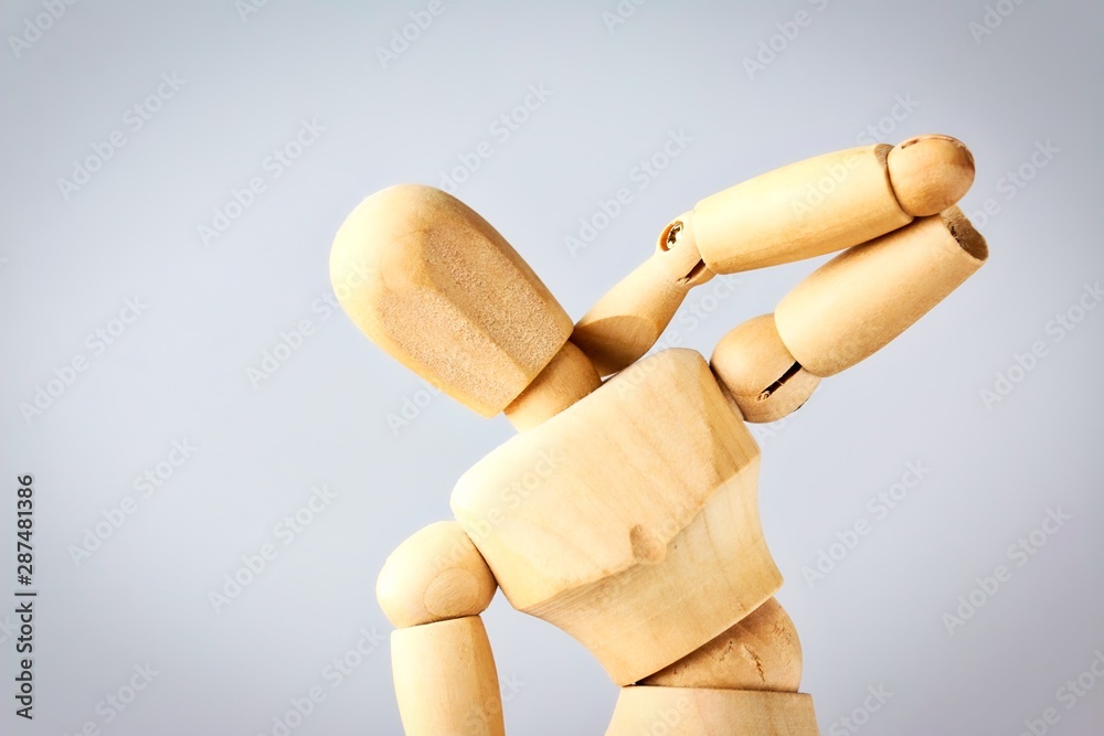 Wooden mannequin figure expressing neck pain.