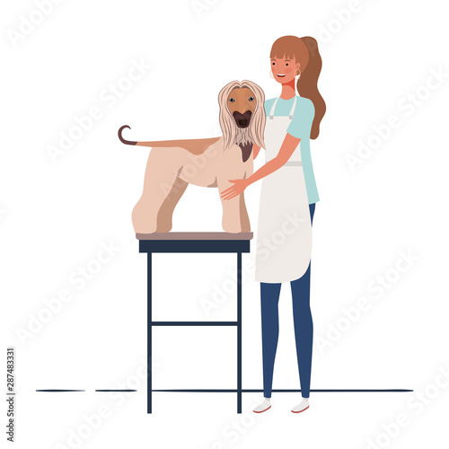 young woman combing a dog in pet groomer