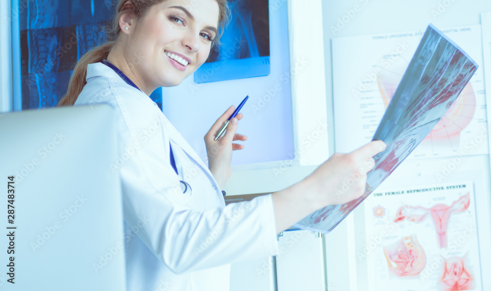 Young professional female doctor examining patient's x-ray Young professional female doctor examining patient's x-ray