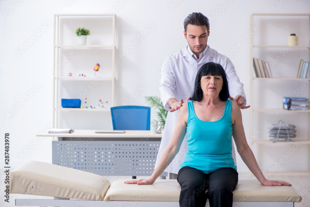 Young male doctor examining old female patient Young male doctor examining old female patient