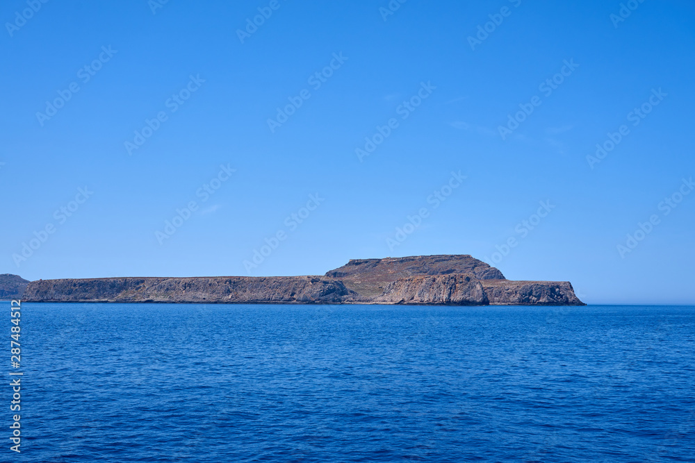 Rocky islands near Crete, Greece, with clear sky on a background and blue sea on a foreground. Copy space.