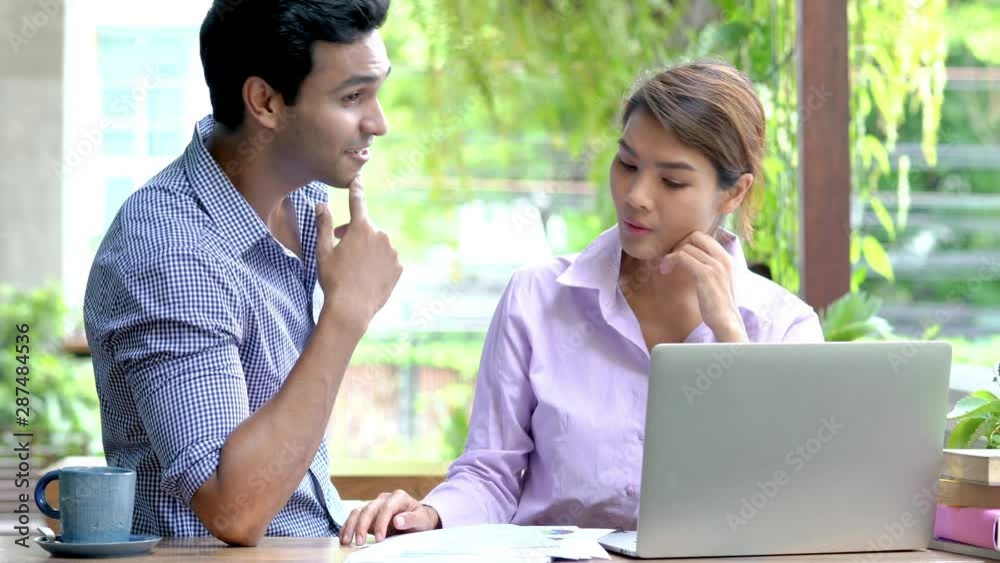 4K Medium shot of asian businessman and businesswoman talking and sharing idea about financial business with using laptop computer and internet at outdoor coffee shop. Outdoor office working concept. 4K Medium shot of asian businessman and businesswoman talking and sharing idea about financial business with using laptop computer and internet at outdoor coffee shop. Outdoor office working concept.