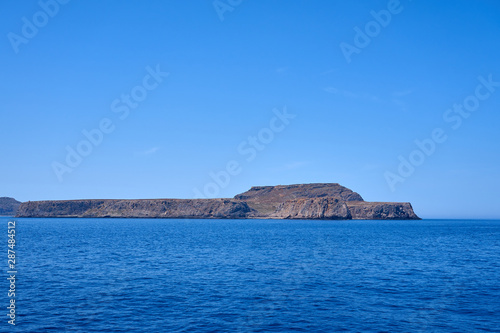  Rocky islands near Crete, Greece, with clear sky on a background and blue sea on a foreground. Copy space. © Arthur
