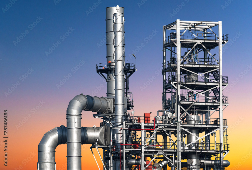 Close-up view Oil and gas industrial refinery zone,Detail of equipment oil pipeline steel with valve from large oil storage tank at cloudy sky. -image