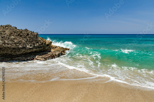 Ocean foamy waves at the beach near rocks  crystal clear turquoise water  Sosua  Puerto Plata  Dominican Republic