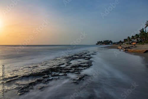 Seascape horizon with rocks in the water and ocean waves at sunrise on Cabarete beach  Dominican Republic