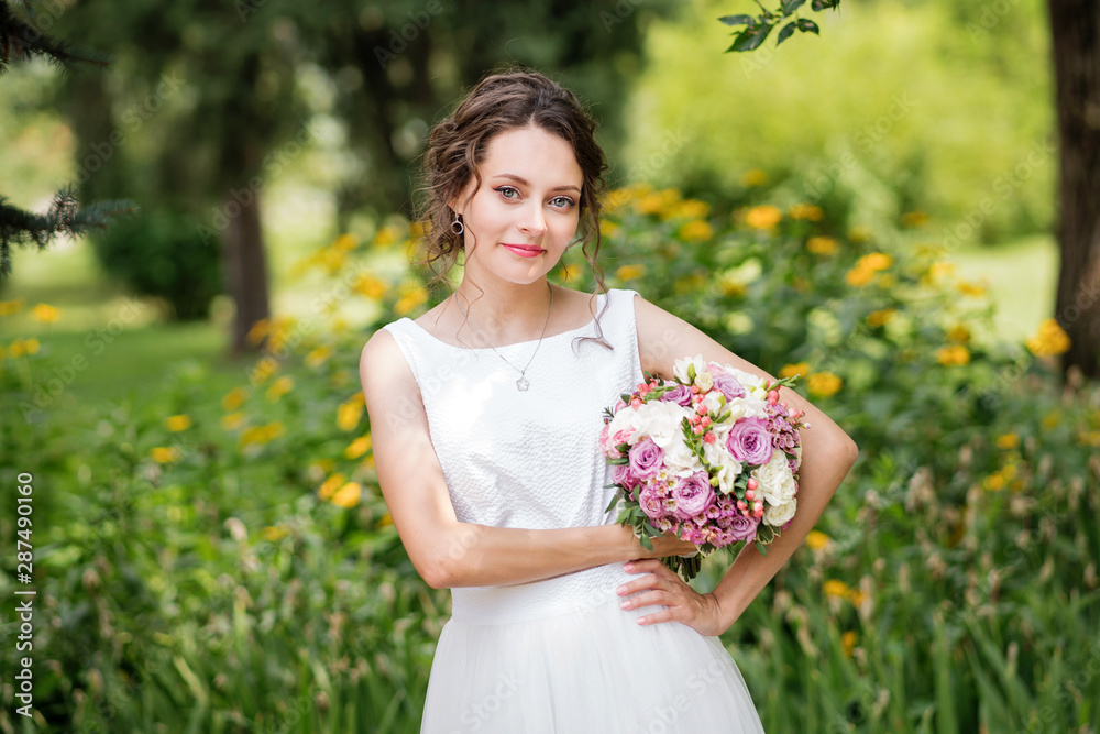Beautiful bride in fashion wedding dress on natural background. The stunning young bride is incredibly happy. Wedding day. A beautiful bride portrait in the park. Beautiful bride in fashion wedding dress on natural background. The stunning young bride is incredibly happy. Wedding day. A beautiful bride portrait in the park.