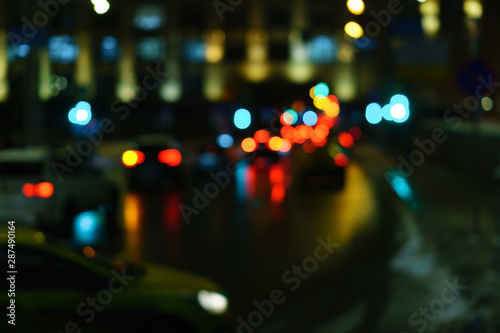 Defocused night city life: cars, people and street lamps. Bokeh urban city background effect. Holidays, sale and retail concept. Design background © Vagengeim