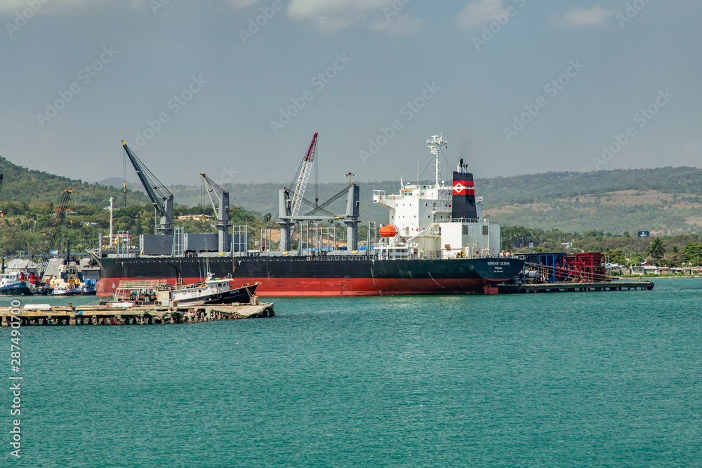Ships, vessels, boats, containers, industrial buildings at the Puerto Plata harbor, port and cityscape, Dominican Republic