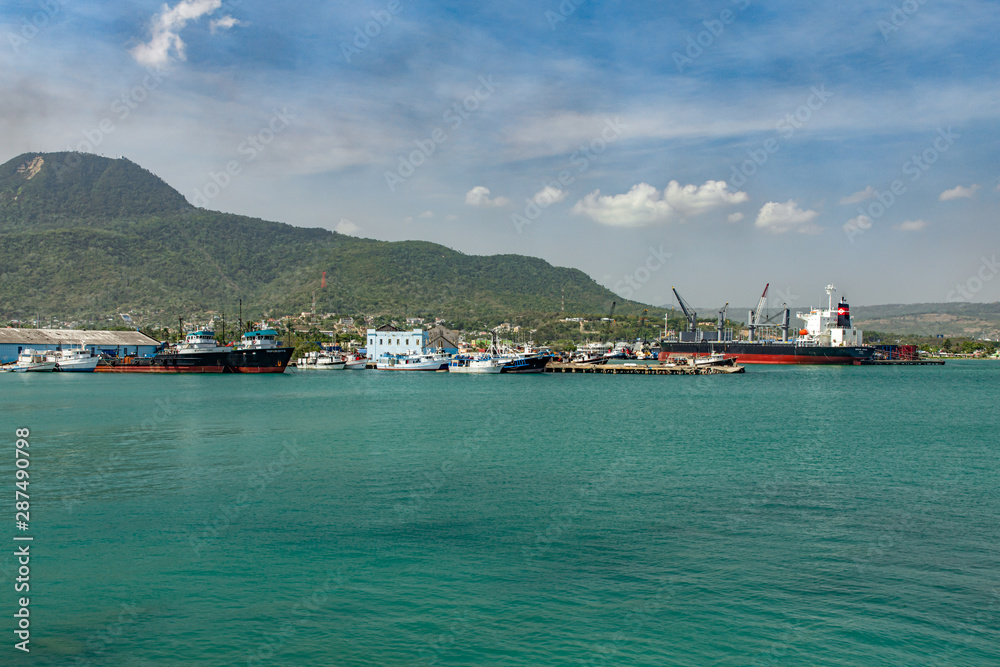 Ships, boats, containers, industrial buildings at the Puerto Plata harbor, port and cityscape, Dominican Republic