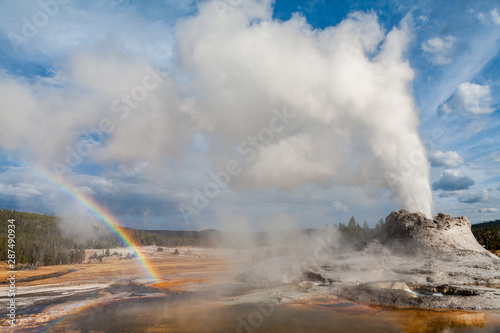 Castle Geyser eruption forms a rainbow in Yellowstone National Park, Wyoming
