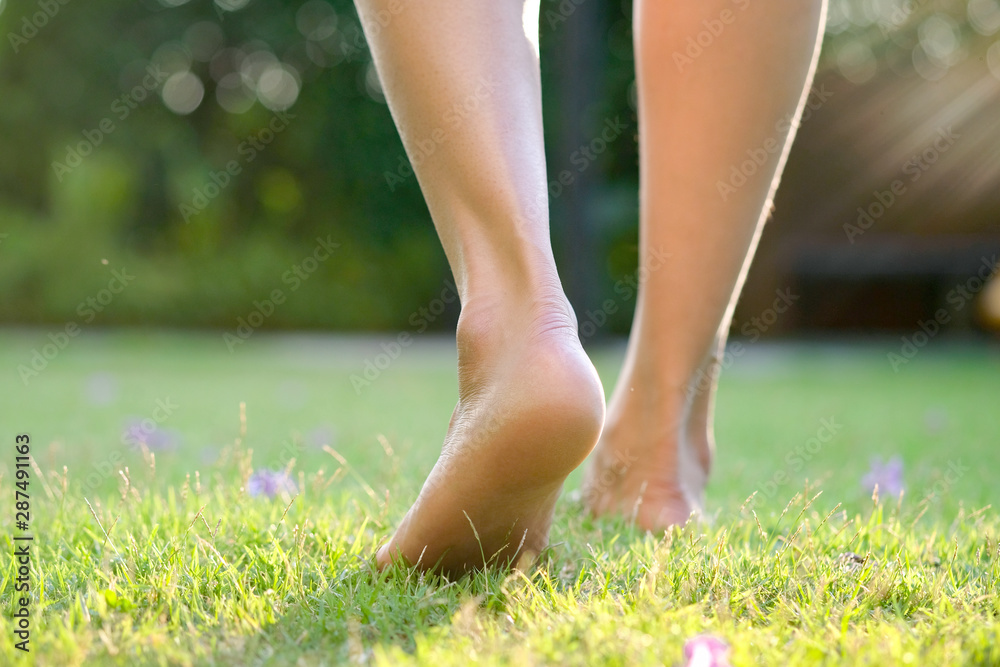 Leg of woman is on the ground. She is about to walk down the grass to exercise in the morning. Health and Relaxation Concepts