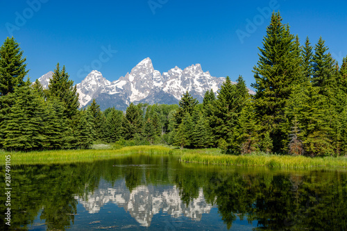 Landscape of mountains and trees of the Grand Teton range reflected in the ponds at Schwabacher Landing, Grand Teton National Park, Wyoming