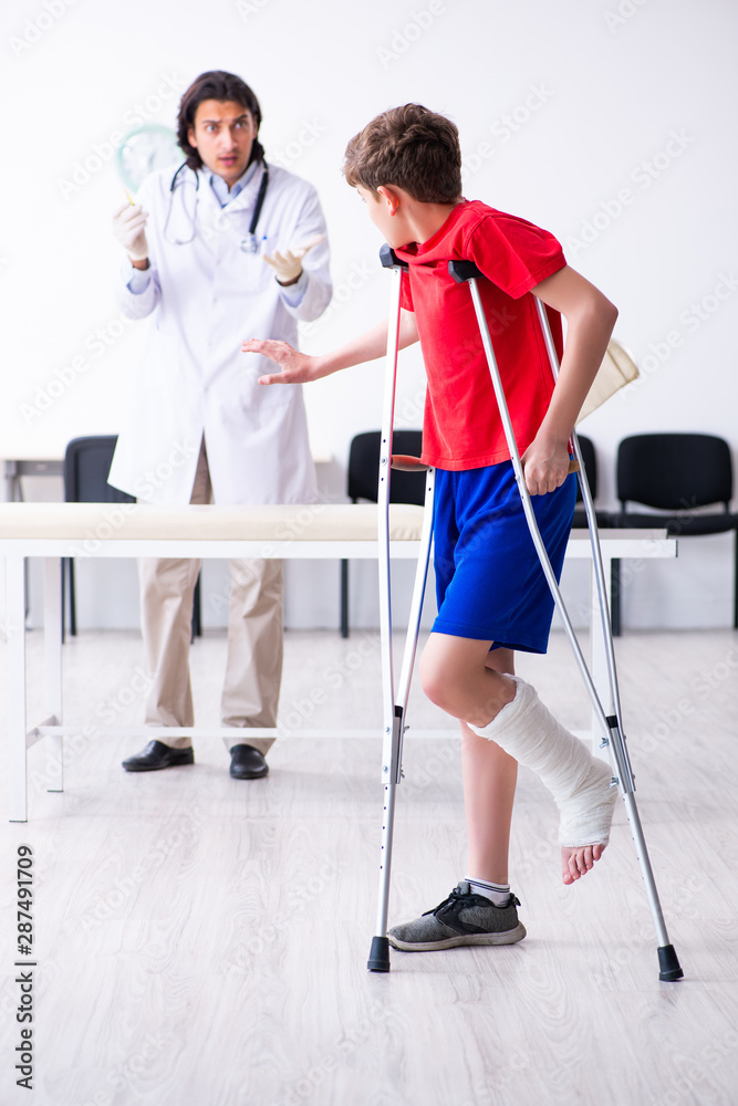 Leg injured boy visiting young doctor traumatologist Leg injured boy visiting young doctor traumatologist
