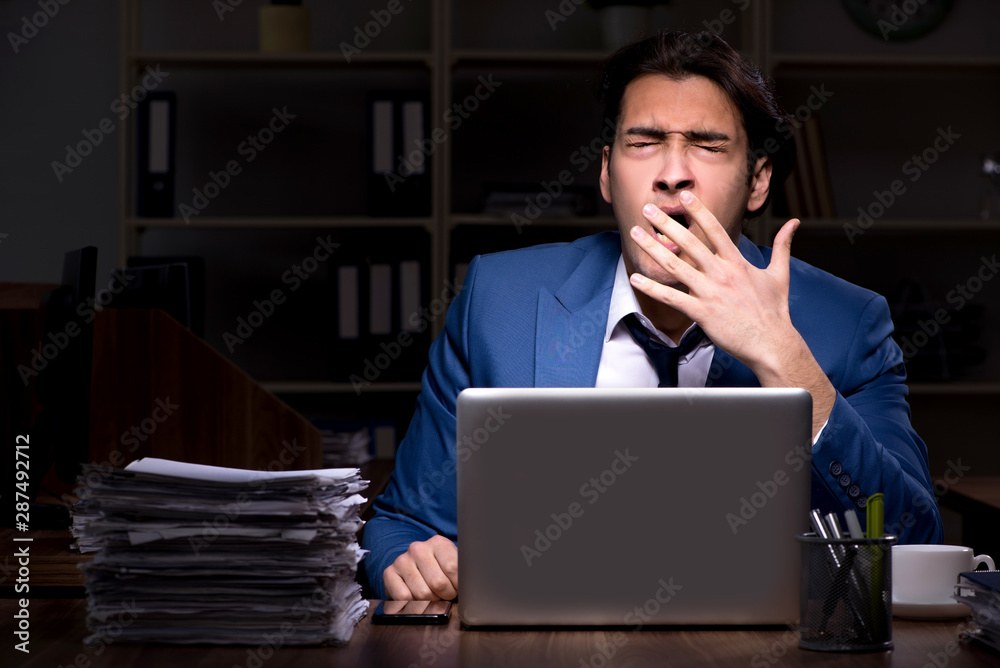Young male employee working night in the office Young male employee working night in the office