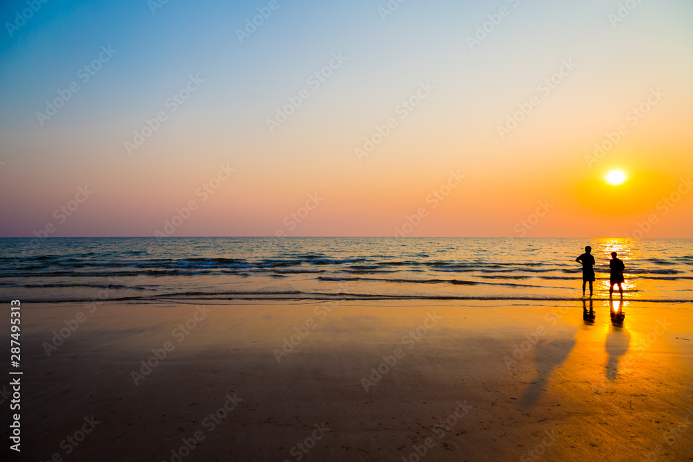 Siluate lovers and beach before sunset