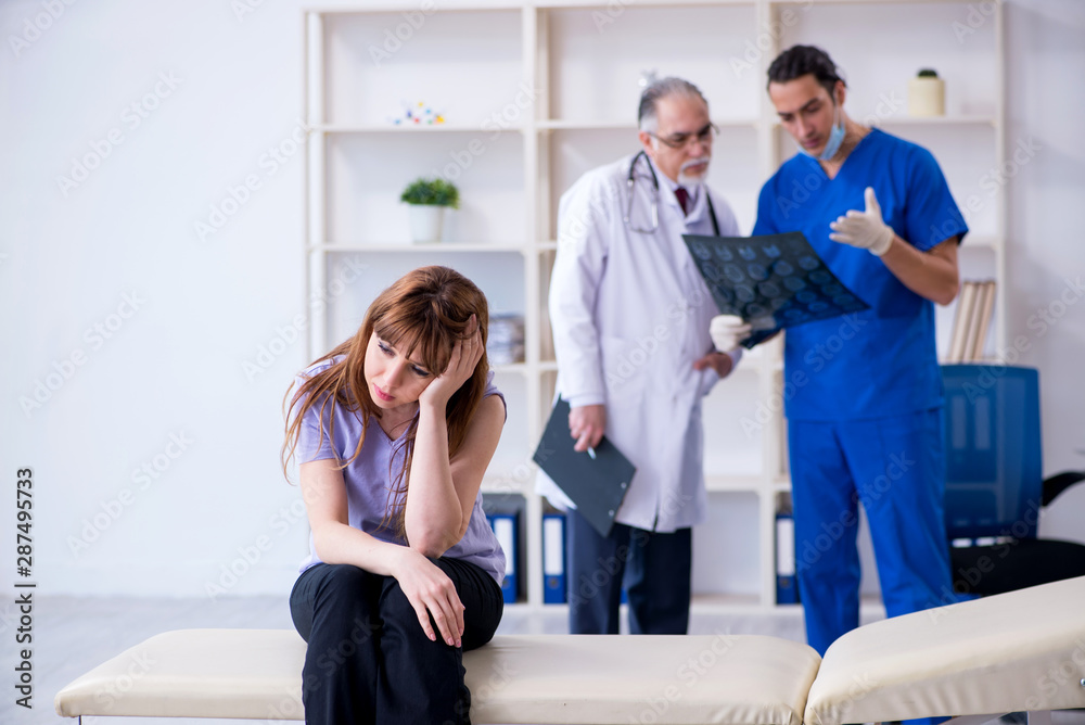 Fototapeta premium Two doctors examining young woman