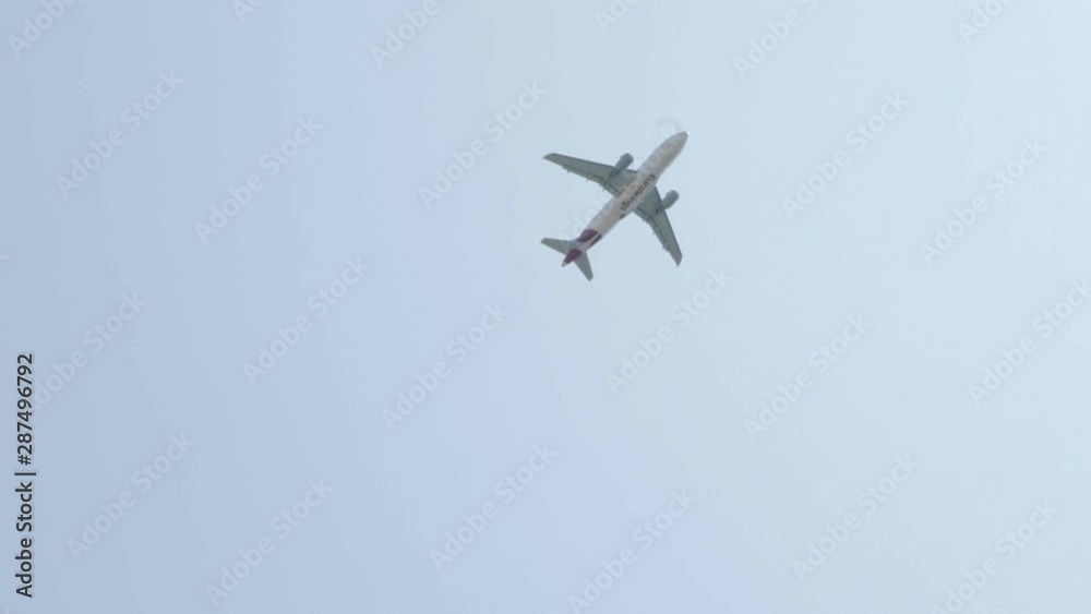 plane lifting up in the sky behind a palm tree in Trogir Croatia// Pan right plane lifting up in the sky behind a palm tree in Trogir Croatia// Pan right