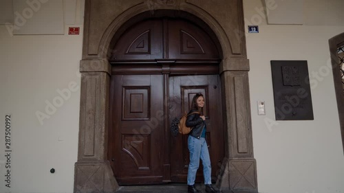 Wallpaper Mural young happy girl in leather jacket comes out of large old door of parliament building Czech Republic Torontodigital.ca