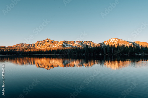 Snowy mountains reflecting in Mirror Lake, in the Uinta Mountains, Utah
