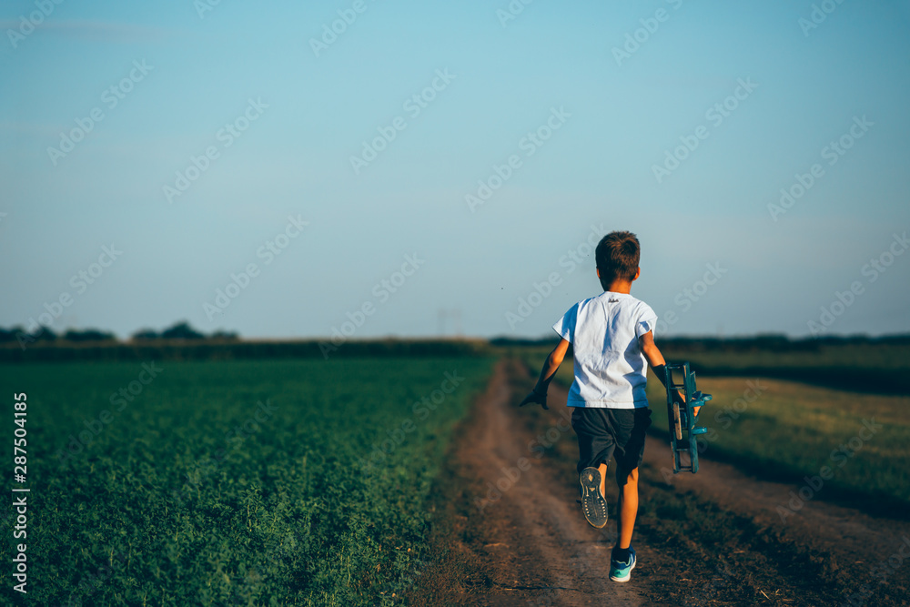 cute boy playing with toy airplane outdoor in meadow cute boy playing with toy airplane outdoor in meadow