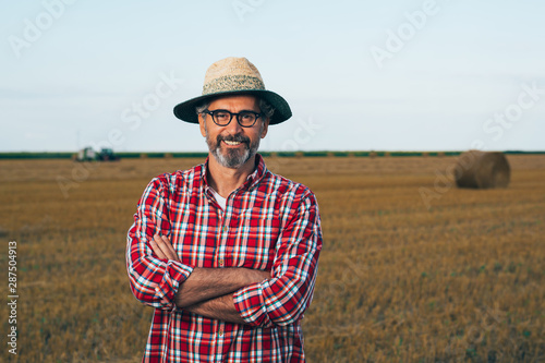 portrait of middle aged rancher standing crossed arms outdoors