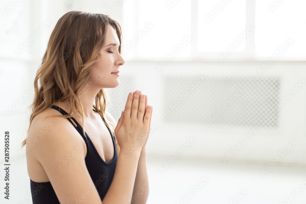Good-looking teen holds her palms together and breathing deeply Good-looking teen holds her palms together and breathing deeply