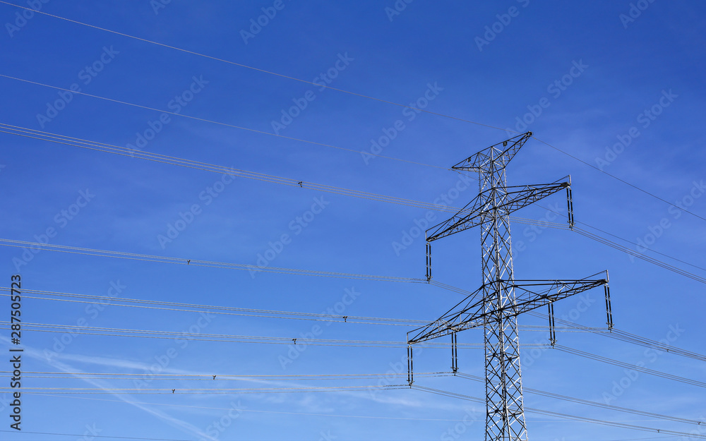Looking up to steel electricity pylon against blue sky with only few clouds streaks Looking up to steel electricity pylon against blue sky with only few clouds streaks
