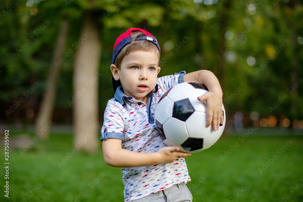 Little child hand holding football and playing soccer on grass with copy space. Little child hand holding football and playing soccer on grass with copy space.