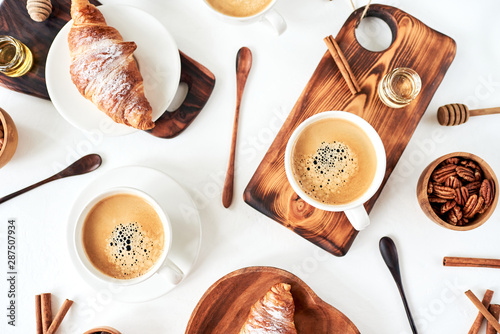 European breakfast, croissant cinnamon coffee, nuts, rekan, almonds, honey, spoon, wooden, top view, good morning, wake up concept, good morning. Top view. photo