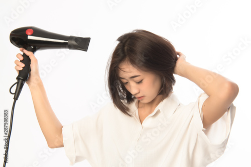 Asian woman uses hair dryer on white background. This image for business woman make up before work.