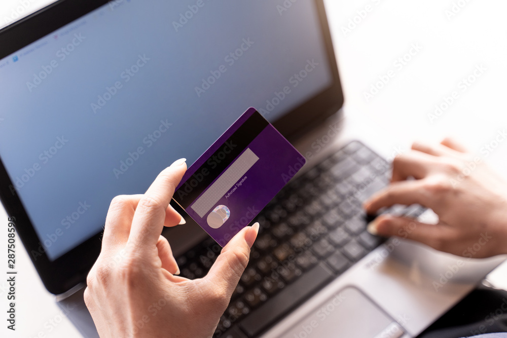 Woman holding credit card and typing on the keyboard of laptop with Shopping cart, online shopping, online payment. Woman holding credit card and typing on the keyboard of laptop with Shopping cart, online shopping, online payment.