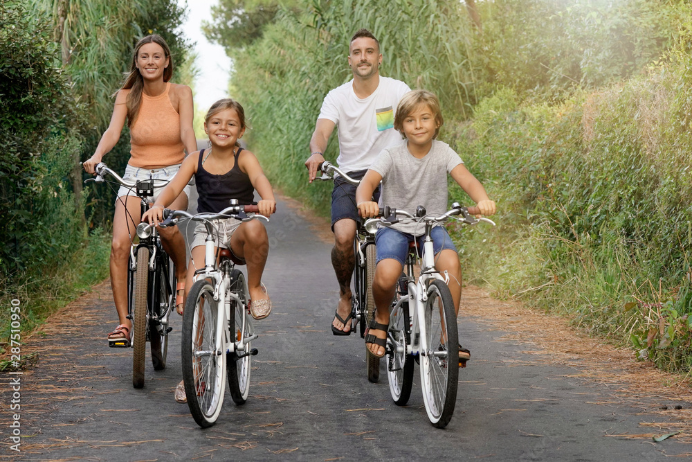 Happy family on vacation riding bikes