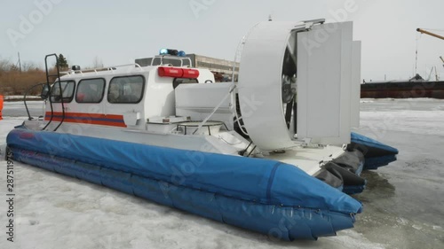 Hovercraft Boat Stand on Ice Lake or River Shore. Extreme Rescue Transport Watersport Ship with Air Cushion. Winter Tourist Entertainment on Frozen Water. Fan Propeller Working on Motorboat