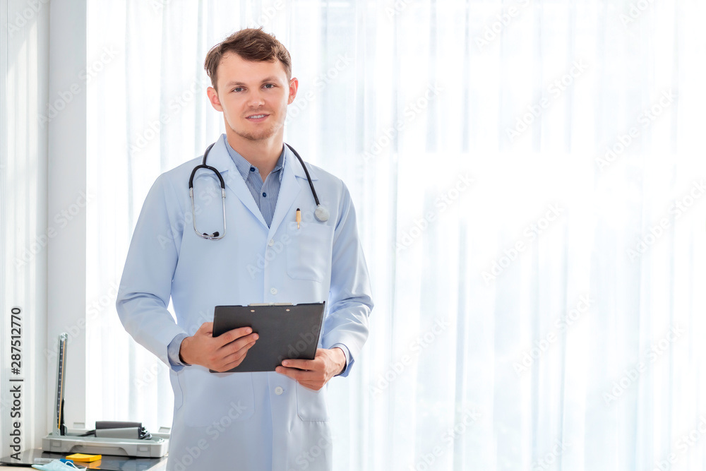 Happy man doctor possing and wearing a stethoscope on hospital room. Happy man doctor possing and wearing a stethoscope on hospital room.