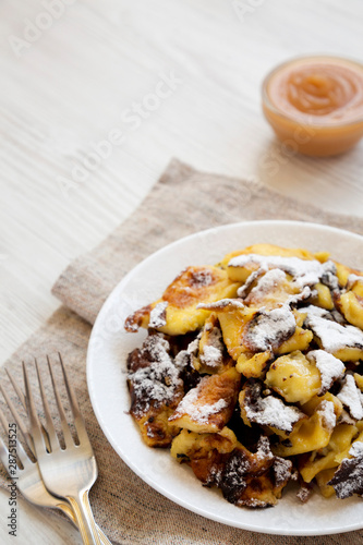 Homemade german Kaiserschmarrn pancake on a white plate, side view. Copy space.