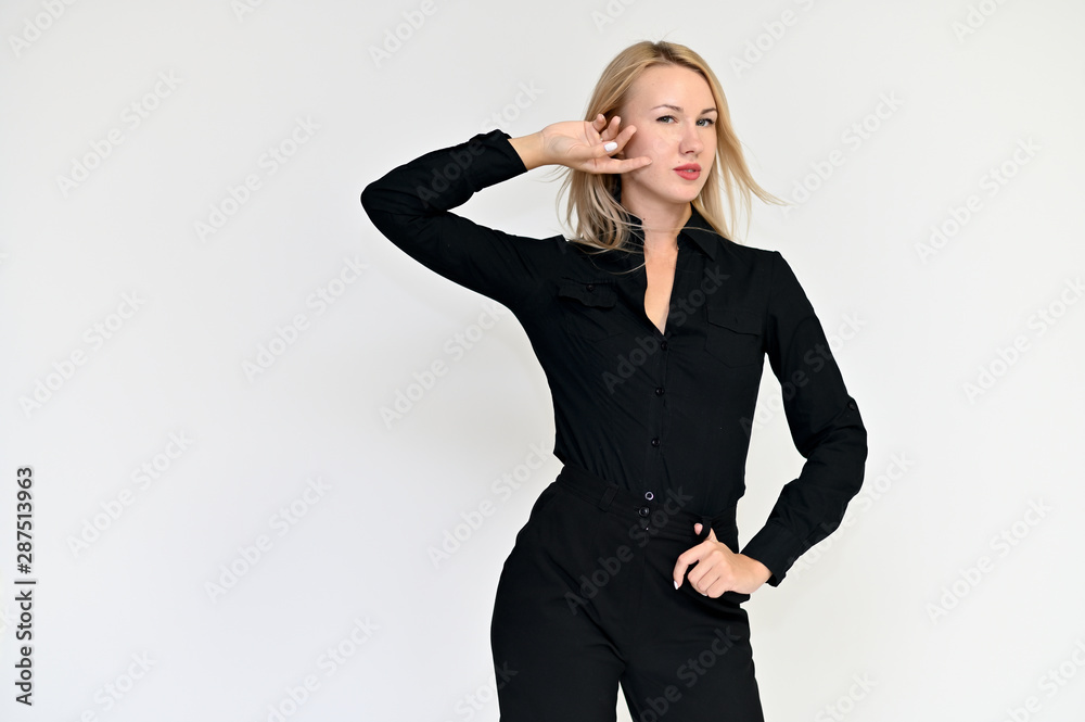 Portrait of a pretty blonde girl in a black suit on a white background. Beauty, brightness, happiness, business look. Shows different emotions in different poses. Portrait of a pretty blonde girl in a black suit on a white background. Beauty, brightness, happiness, business look. Shows different emotions in different poses.