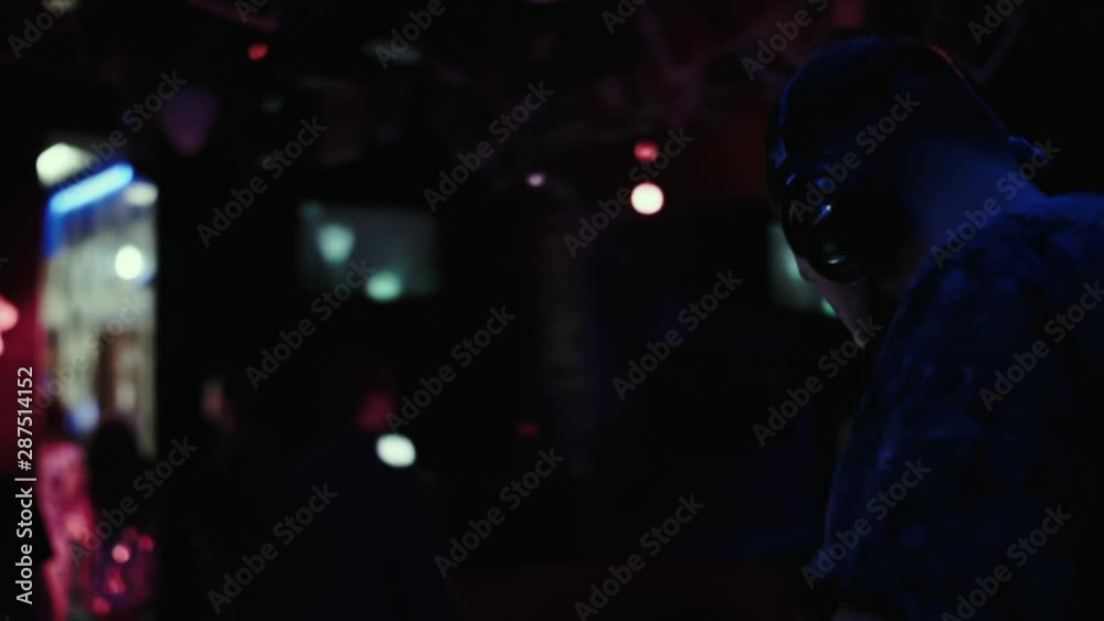 DJ at the console mixes music in a night dance club. DJ at the console mixes music in a night dance club.
