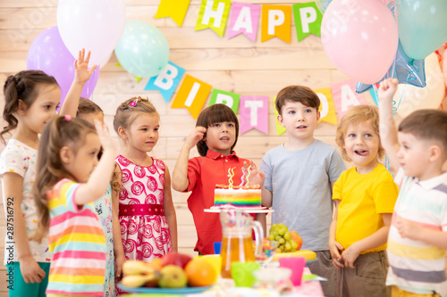 Group of adorable kids gathered around festive table. Birthday children party