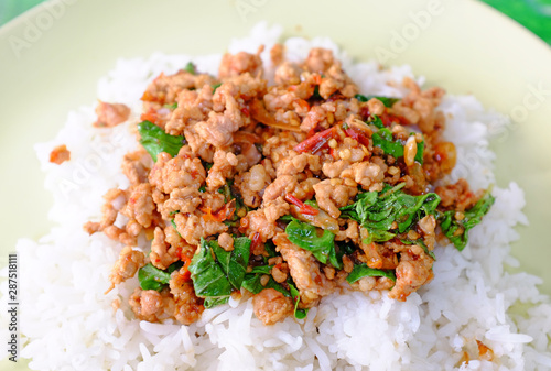 Close-up Rice topped with Minced pork and basil leaf. Traditional Thai street food.
