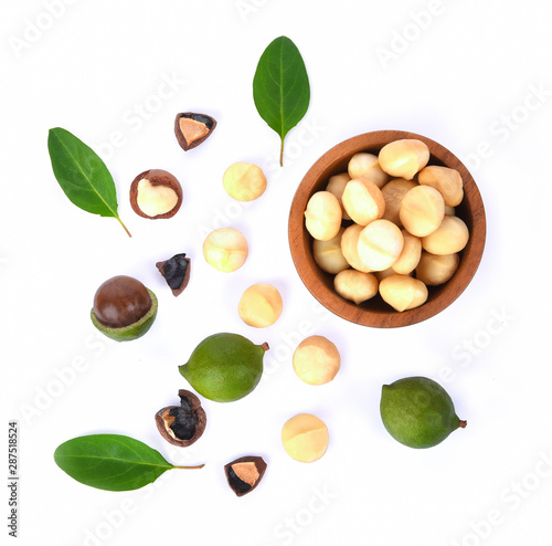 Fototapeta Naklejka Na Ścianę i Meble -  Shelled and unshelled macadamia nuts with leaves isolated on white background. Top view. Flat lay pattern