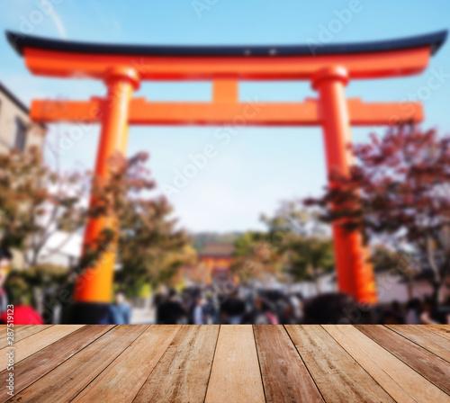 Wallpaper Mural Wooden table top over blur background of Japanese red torii main gate. Torontodigital.ca