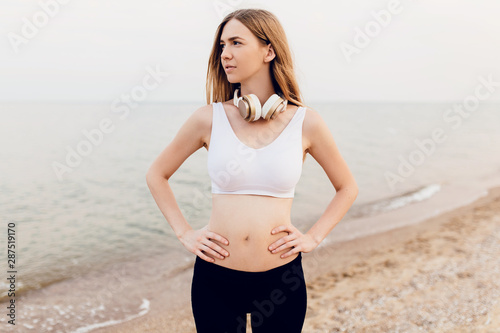 young girl in sportswear in the morning outdoors on the beach