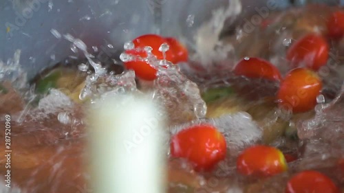 Tomatoes industrial washing with clean cold water splash drops in a factory. Macro close up.